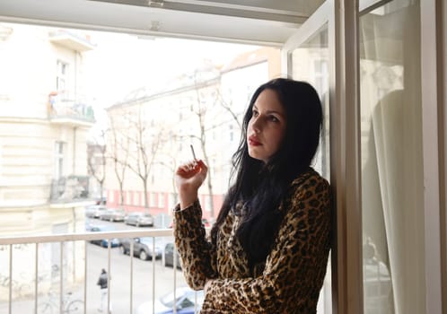 Woman smokes at the window