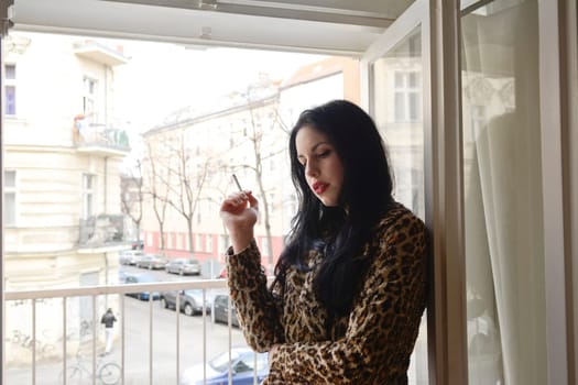 Woman smokes at the window