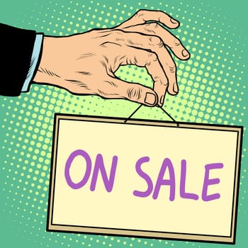 Hand holding a sign on sale pop art retro style. Advertising signs. Vector business concept