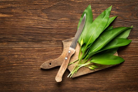 Wild garlic leafs on wooden background overhead shoot