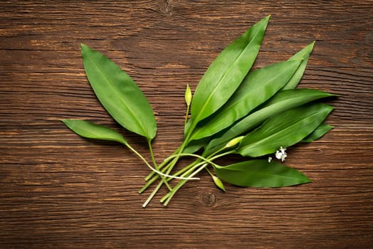 Wild garlic leafs on wooden background overhead shoot