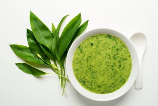 Fresh wild garlic soup on white background overhead shoot