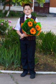 the lovely school student costs with a bouquet of flowers