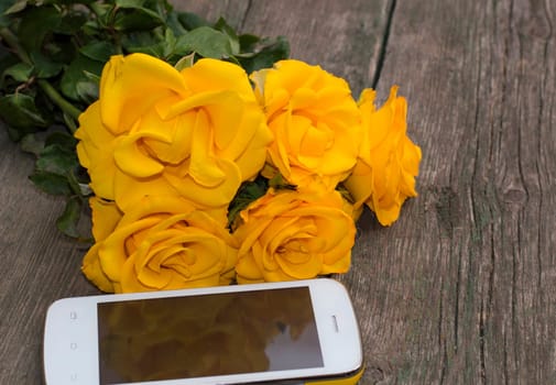 bouquet of yellow roses and their reflection in the phone