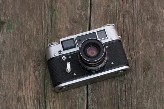 the old film camera lies on a wooden table