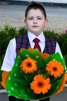 the beautiful school student with a bouquet of bright orange flowers