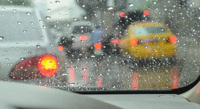 Blurry car seen through wet windscreen in rainy day