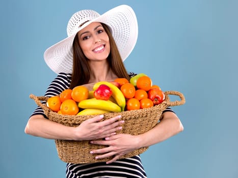 young caucasian woman holding fruit basket on white background