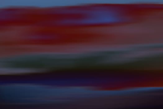 A blurred and abstract sky with different colored clouds.