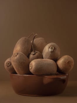 Kiwi in a bowl of brown on brown background to understand a principle of healthy eating