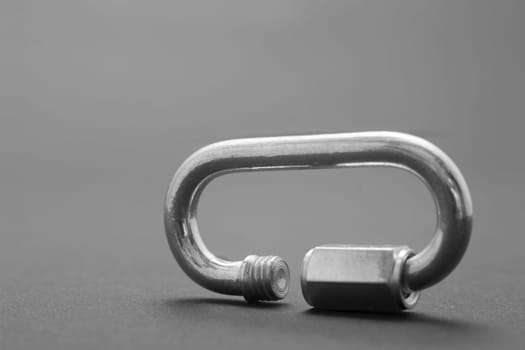Steel screw carabiner isolated on dark background
