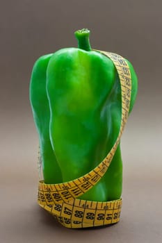 Green pepper isolated on a brown background to understand a concept to healthy eating