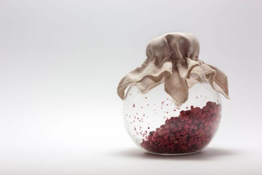 Pepper in glass container on white background