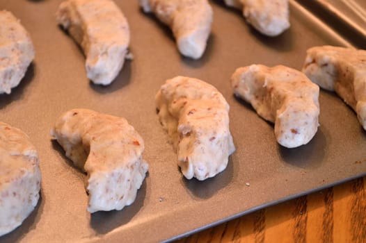 Raw cookie dough, on baking sheet ready to go in the oven. Crescent cookies in moon shapes.