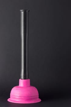 Rubber plunger with plastic handles on a dark background