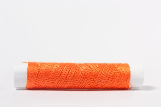 Orange cotton thread on a white background