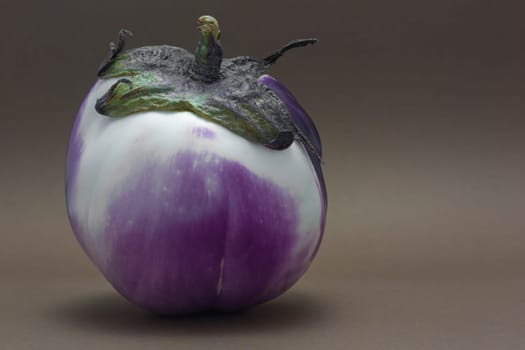 Ripe fresh eggplant isolated on brown background as a concept of healthy nutrition