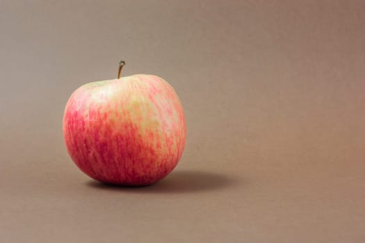Ripe red apple on a brown background