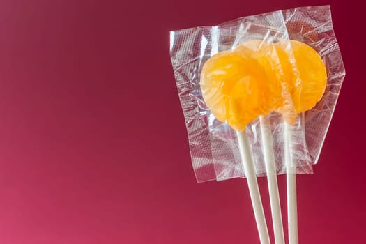 Three lollipops wrapped background amaranth