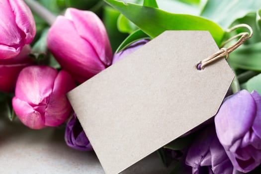 Pink and purple tulips and blank card with copy space for Mother's Day or Easter Greeting.