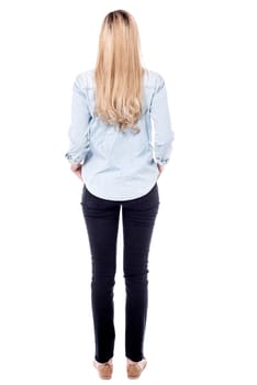 Tall woman facing away, white background.