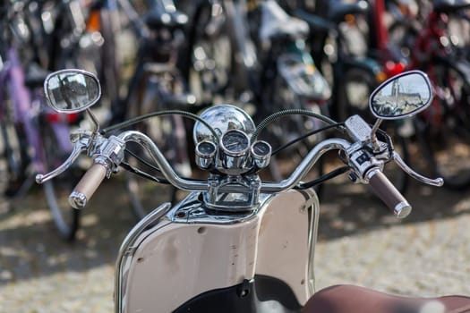 handlebar with chrome instruments and headlight of a scooter
