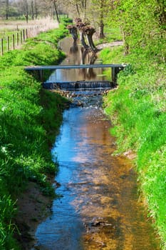 picturesque brook landscape between agricultural fields in The Netherlands