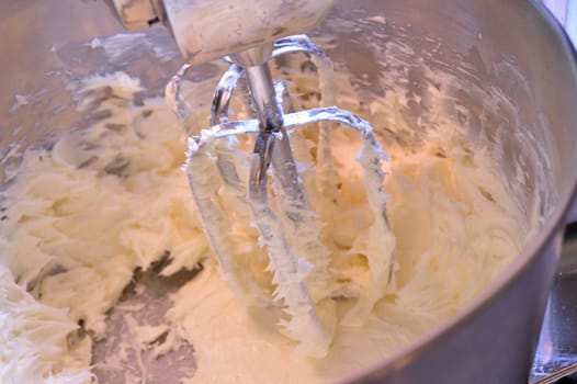 Creamed butter in a stainless steel stand mixer. Butter creamed for use in baking and icings.