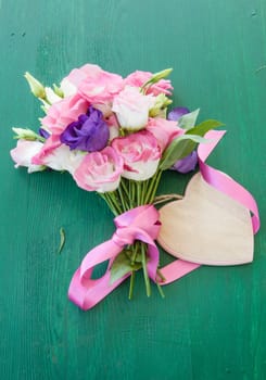 Fresh colorful Japanese rose on rustic background made of wood