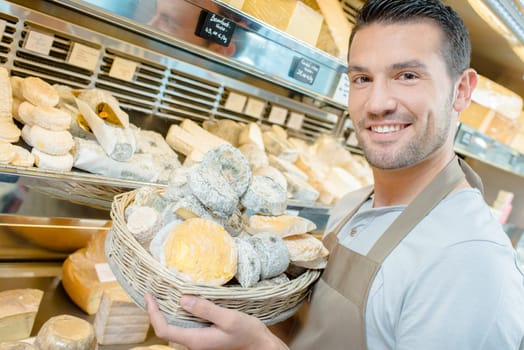 Man stocking the shelves in a cheese shop