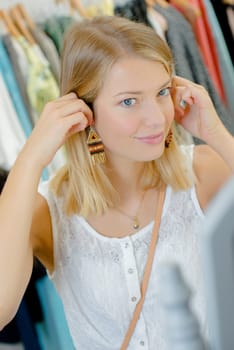 Woman trying on a pair of earrings