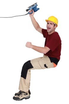 joyful carpenter holding sander machine