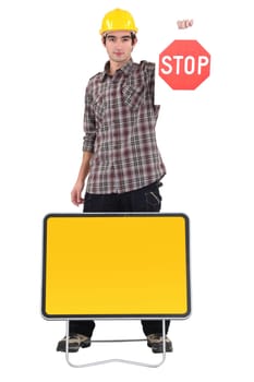 Young bricklayer holding stop sign