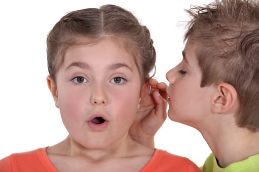 Boy whispering into girl's ear