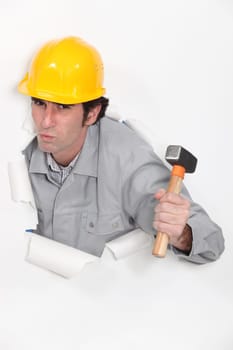 carpenter with hammer against torn paper background