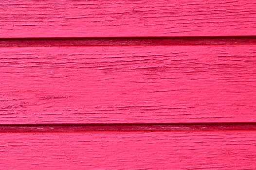 Wood slats running horizontal, distressed, chipping paint job, in hot pink.