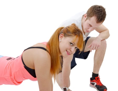 male trainer assisting young woman doing push-up isolated on white background