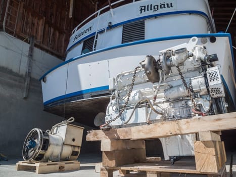 Rear view of the MS Allgäu with the engine in front of it on wooden scaffolding in the boathouse in Fuessen am Foggen-See in Fuessen