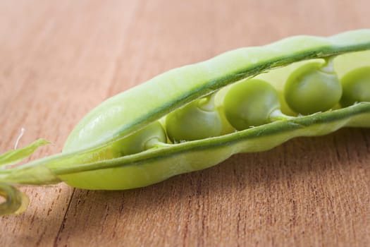 Pea pod slightly opened showing fresh peas