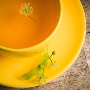 Yellow cup with linden tea on the table,  top view
