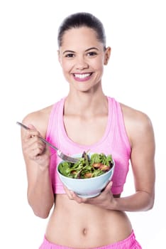 Slim young trainer eating salad