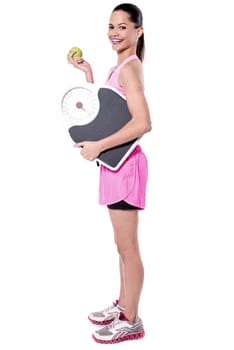 Side pose of lady holding weighing scale