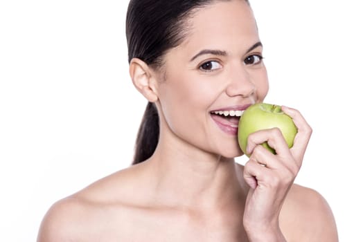 Spa woman biting apple and posing to camera