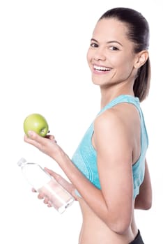 Young athlete holding water bottle and apple