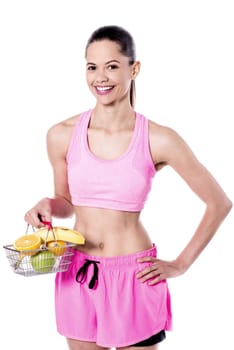 Young fit woman with cart of exotic fruits