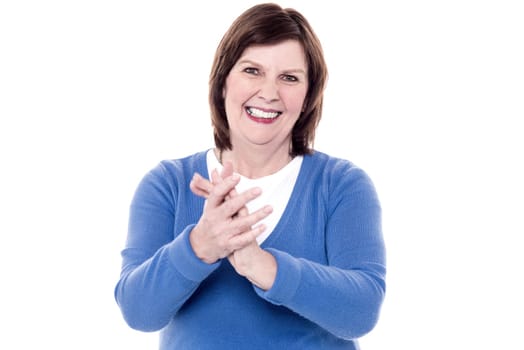 Female senior cheerfully claps her hands over white