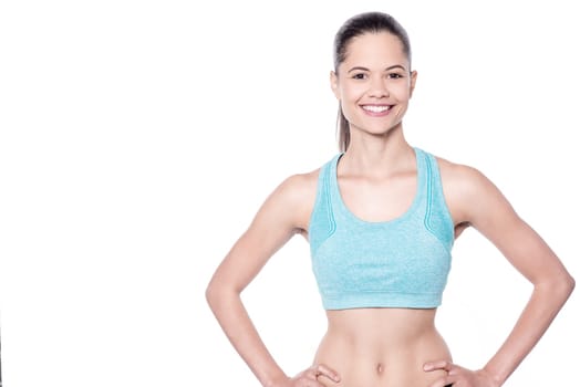Fitness woman posing to camera with hands on waist
