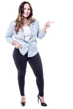 Happy woman pointing index finger at something