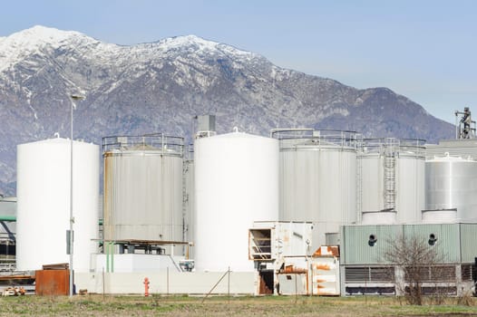 Tanks of a chemical plant at the foot of the mountains.