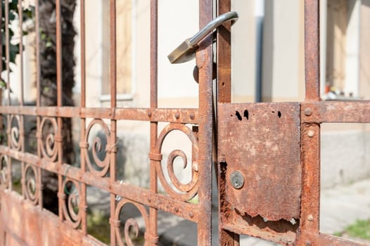 Rusty metal gate closed with padlock - concept image